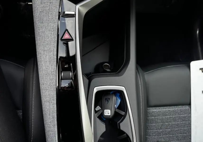 Vue plongeante sur la console centrale du Peugeot 5008 2025, avec clé et tissu gris chiné RIMINI visible.