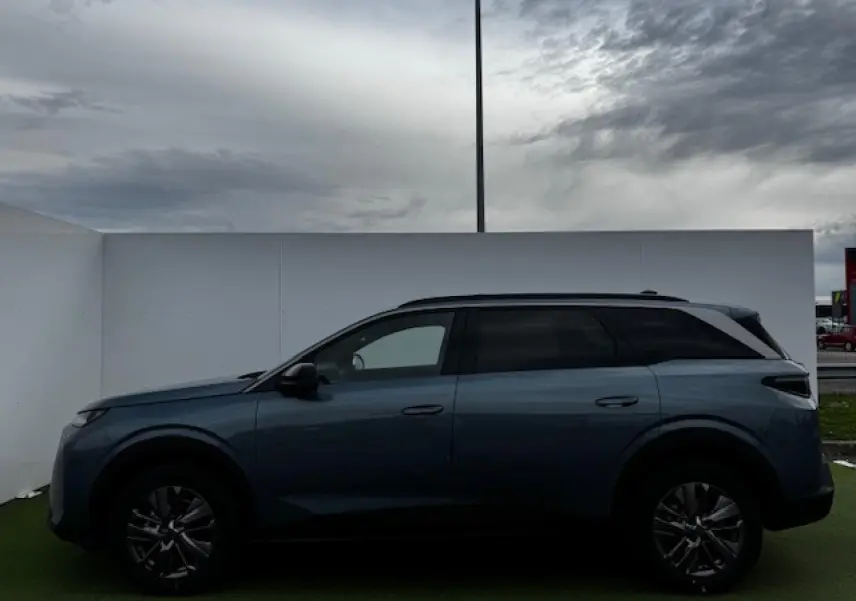 Profil latéral droit du Peugeot 5008 bleu Ingaro métallisé avec jantes alliage et toit noir contrasté.