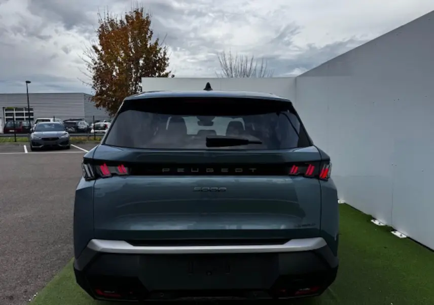 Vue arrière du Peugeot 5008 bleu Ingaro métallisé 2025 avec feux arrière à LED en forme de griffes distinctives.