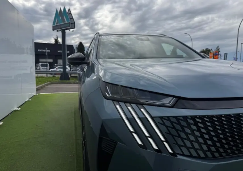 Vue 3/4 avant gauche du Peugeot 5008 bleu Ingaro avec ses phares LED à griffes distinctives et calandre noire.