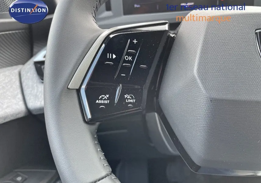 Gros plan sur les commandes au volant à gauche du Peugeot 3008 Hybrid bleu Ingara Metal, avec boutons d'assistance et limitation.