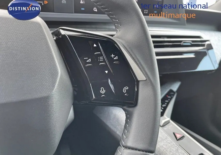Gros plan sur les commandes tactiles du volant en cuir noir du Peugeot 3008 Hybrid 2025, intérieur moderne et épuré.