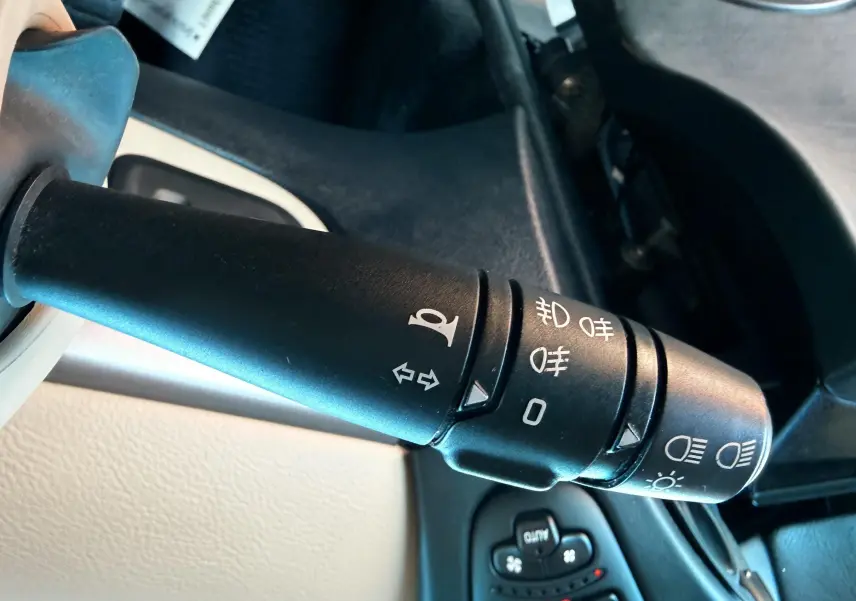 Gros plan sur la manette de clignotants et phares du Renault Avantime gris, côté gauche du volant.
