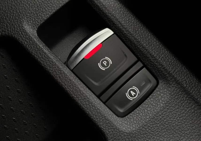 Gros plan sur les commandes du frein de parking électrique et de l'arrêt automatique dans l'habitacle du Renault Captur gris Cassiopée 2025.