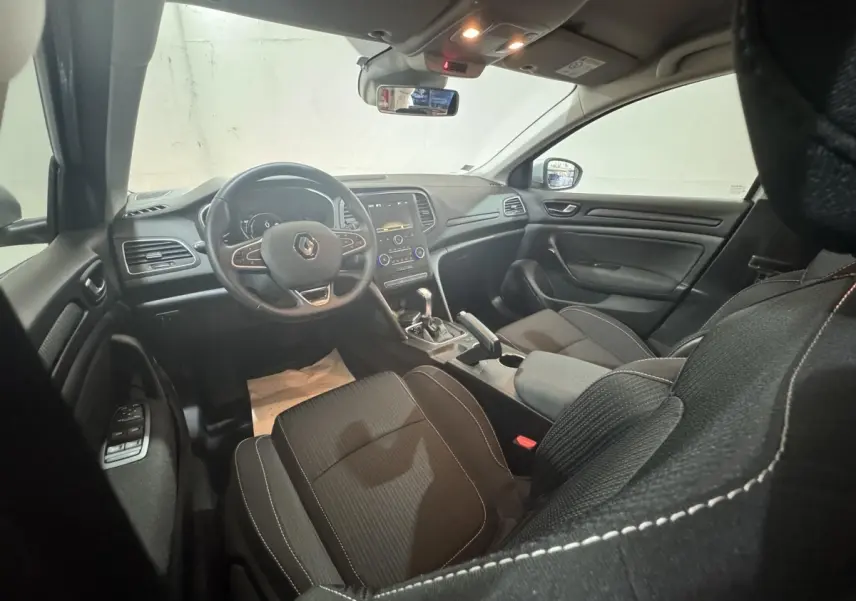 Vue intérieure avant droite de la Renault Mégane Business 2019, volant cuir multifonctions et écran tactile central visible.
