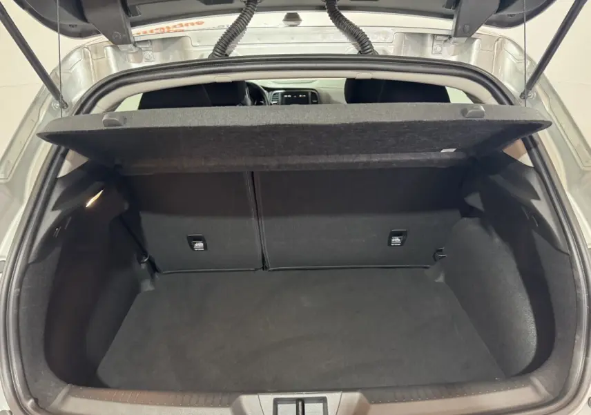 Coffre ouvert de Renault Mégane gris clair, vue arrière montrant l’espace de chargement et la tablette cache-bagages.