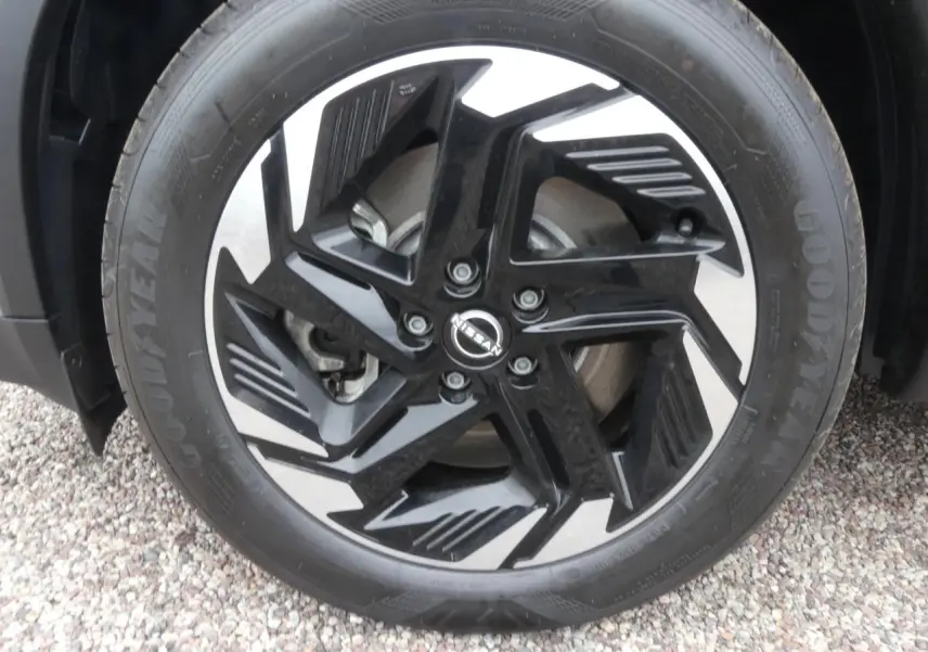 Gros plan sur la jante alliage 18 pouces bicolore noire et argentée du Nissan Qashqai gris métallisé.