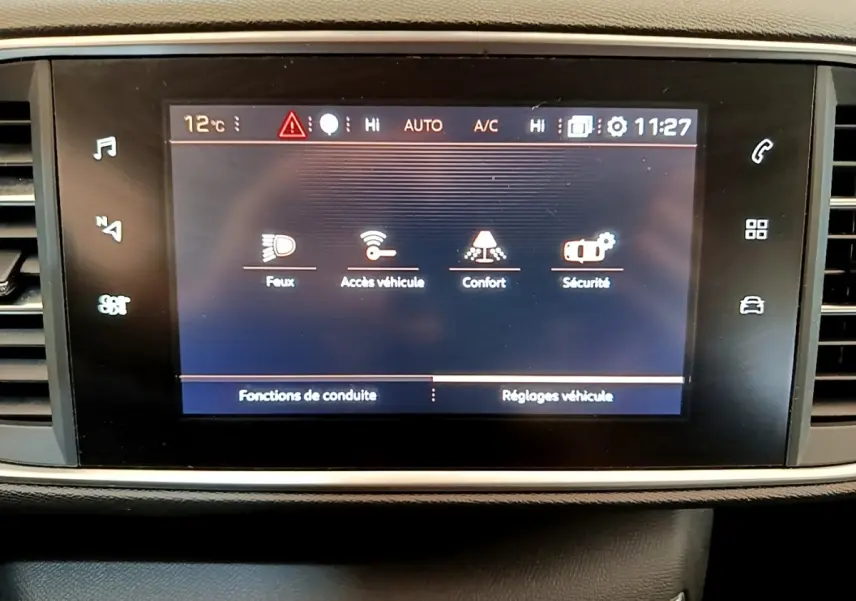 Écran tactile central de la Peugeot 308 blanc, affichant les réglages de conduite et sécurité.