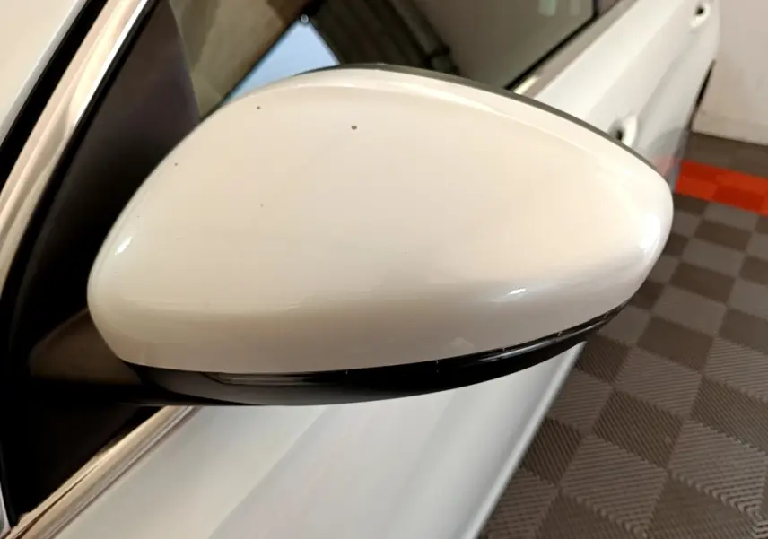 Rétroviseur droit blanc de Peugeot 308 2017 vue rapprochée avec clignotant intégré, sur fond intérieur garage.