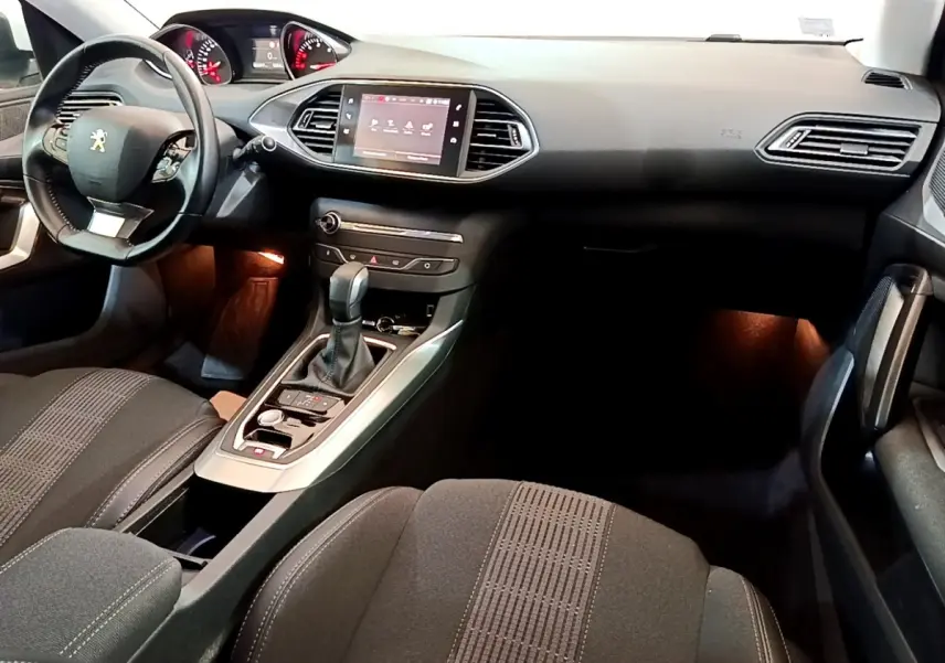 Vue intérieure avant droite du Peugeot 308 blanc 2017, avec tableau de bord moderne et écran tactile central.