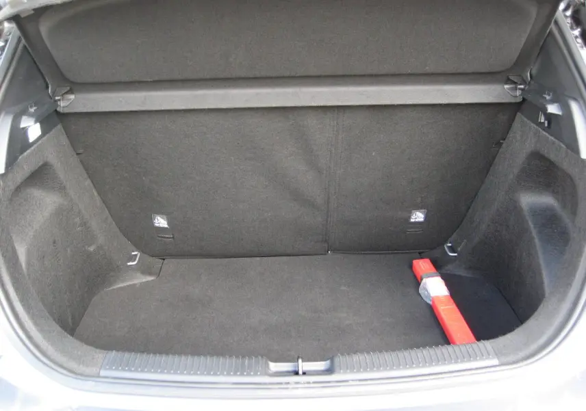 Coffre ouvert d’un MG3 gris 2025, vue de l’arrière montrant un espace de rangement propre avec un triangle de signalisation rouge.