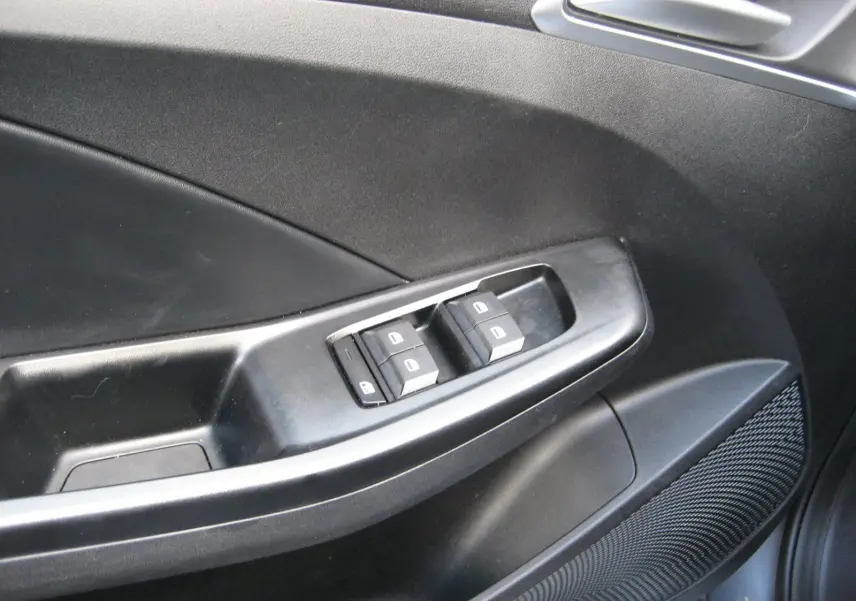 Gros plan sur la commande des vitres électriques côté gauche d’une MG3 1.5 Hybrid gris, intérieur noir.