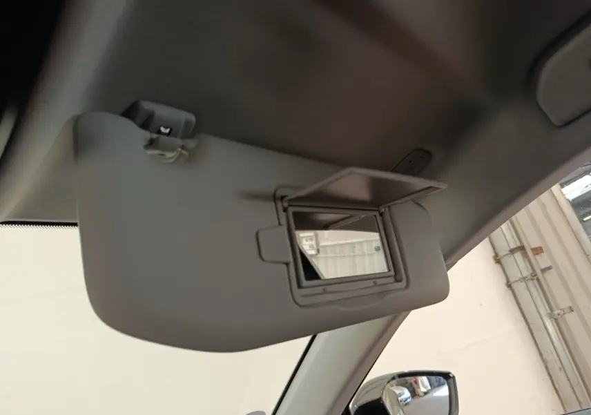 Vue intérieure du pare-soleil côté conducteur avec miroir ouvert sur Peugeot 308 vert, reflet du rétroviseur extérieur visible.