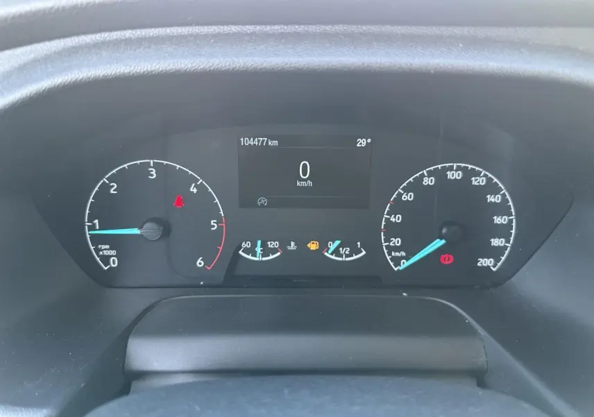 Vue rapprochée du tableau de bord du Ford Transit Fourgon blanc, affichant le compteur et l'ordinateur de bord à l'arrêt.