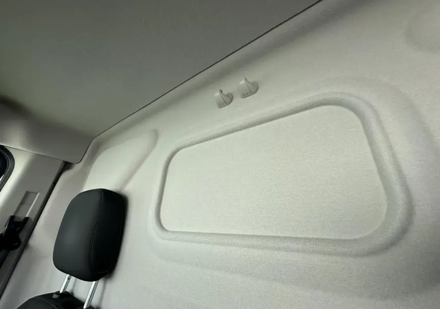Détail de la cloison intérieure beige et appuie-tête noir du siège conducteur du Ford Transit Fourgon blanc 2020.