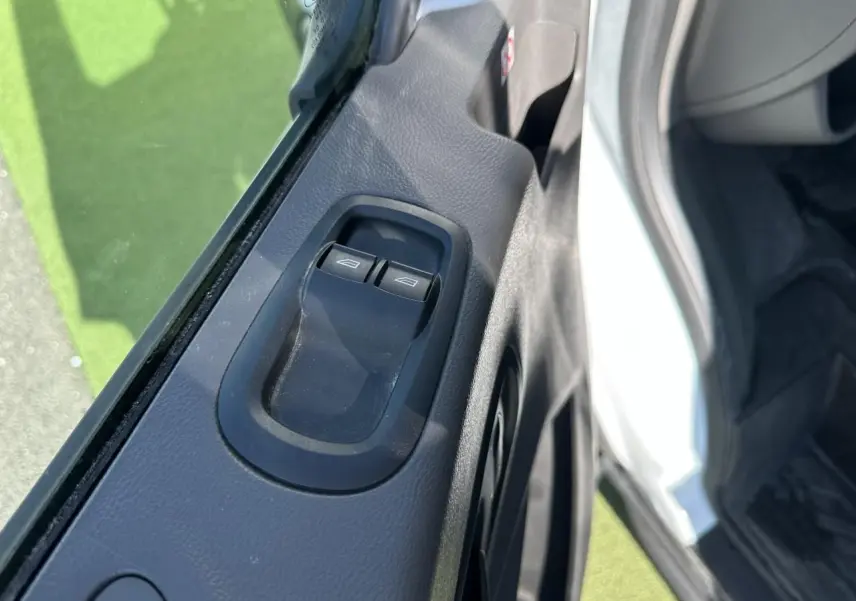 Gros plan sur les commandes de lève-vitres côté conducteur du Ford Transit Fourgon blanc, intérieur noir.