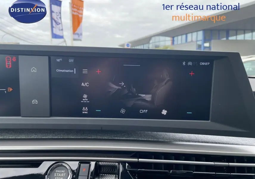 Vue intérieure du tableau de bord du Peugeot 3008 Hybrid 2025, écran tactile affichant la climatisation et bouton start/stop.