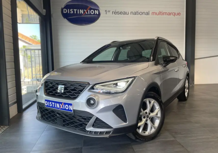 SEAT Arona 2024 gris GRS vu en 3/4 avant droit, avec calandre noire et jantes alliage 16 pouces.