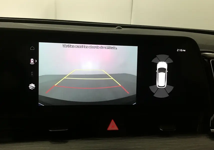 Écran digital 12,3'' du Kia Sportage 2025 affichant la caméra de recul et l'aide au stationnement active.