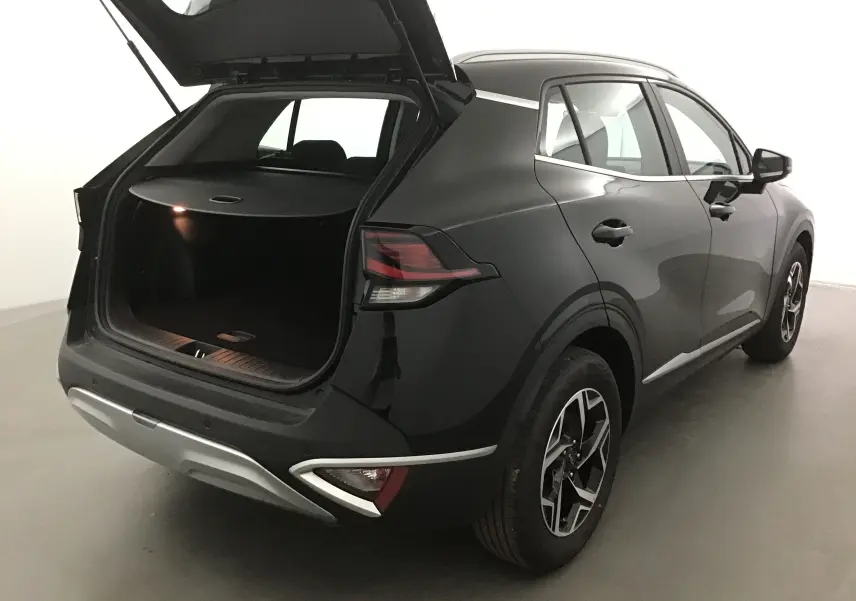 KIA Sportage noir 2025 vu 3/4 arrière droit avec coffre ouvert, feux arrière LED et jantes alliage 17 pouces.