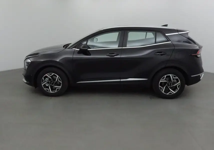 Vue latérale côté gauche d'un KIA SPORTAGE noir 2025 avec jantes alliage et lignes de carrosserie sculptées.