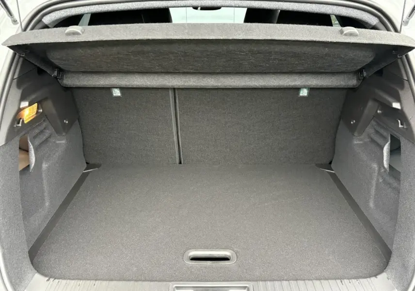 Coffre ouvert du Renault Captur blanc nacré 2025, vue intérieure montrant l’espace de rangement et la tablette arrière.