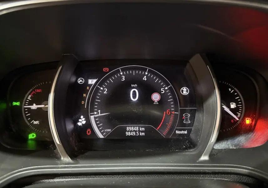 Tableau de bord numérique de Renault Mégane Intens gris foncé, affichage vitesse à 0 km/h et jauge essence rouge.