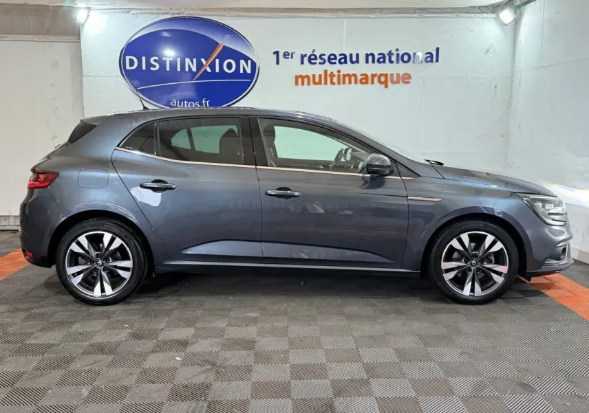 Profil côté gauche d'une Renault Mégane Intens gris foncé de 2019, avec jantes alliage et feux avant allumés.