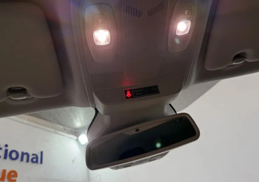 Vue intérieure en contre-plongée du plafonnier gris clair avec éclairage et rétroviseur dans une Renault Mégane gris foncé.