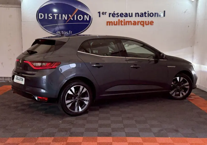 Renault Mégane Intens gris foncé vue de profil côté droit en intérieur avec jantes alliage et feux arrière LED.