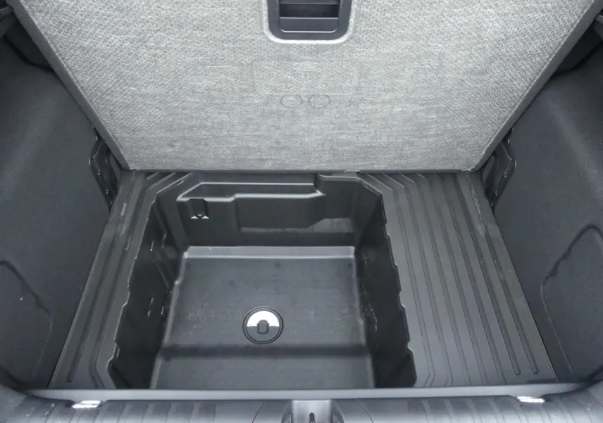 Vue plongeante sur le compartiment de rangement sous le plancher de coffre du Ford Puma 2025 gris métallisé.