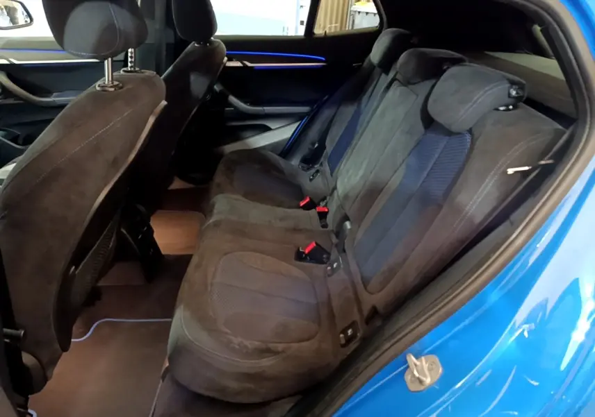 Vue intérieure côté droit sur la banquette arrière noire avec détails en tissu du BMW X2 bleu 2019.