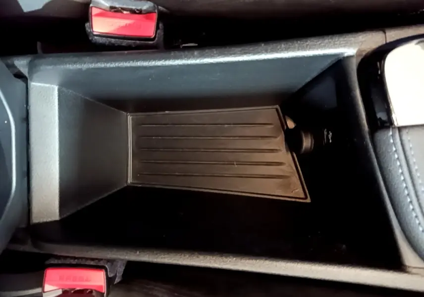 Gros plan sur le rangement central noir entre les sièges avant de la BMW X2 sDrive20i M Sport DKG7 2019.