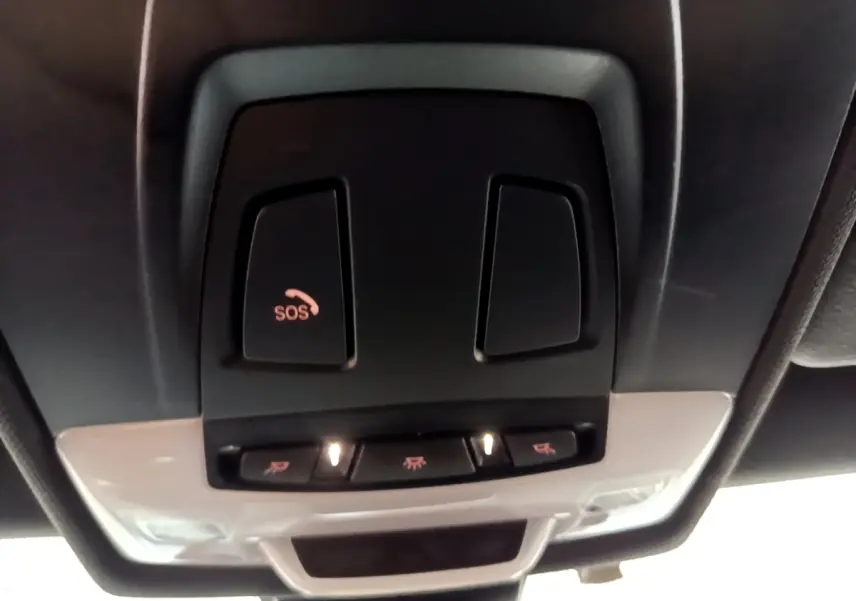 Vue en gros plan du plafonnier noir avec bouton SOS éclairé dans l'habitacle d'une BMW X2 bleu 2019.
