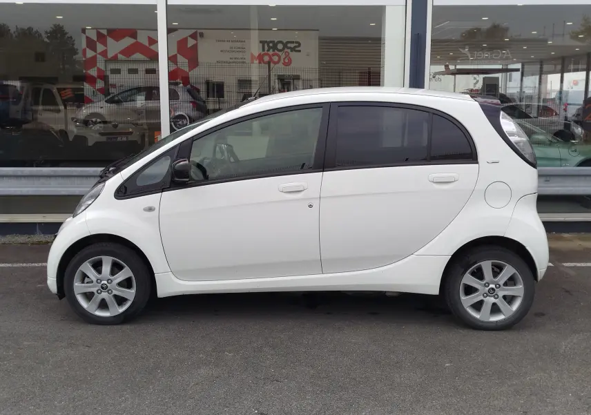 Vue de profil côté gauche d'une Citroën C-Zero Confort blanche Antarctique, compacte et électrique, avec jantes alliage 15 pouces.