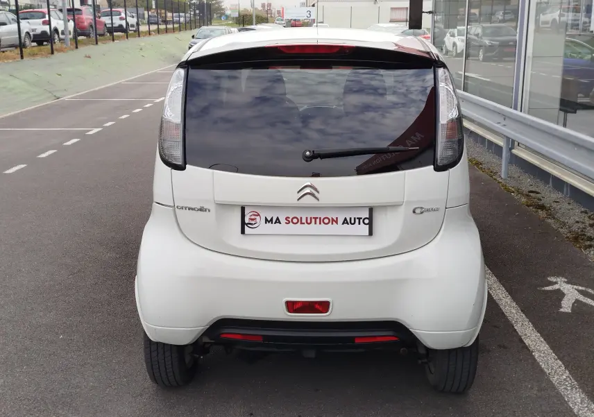 Vue arrière d'une Citroën C-ZERO Confort blanche Antarctique, avec vitre arrière teintée et feux verticaux distinctifs.