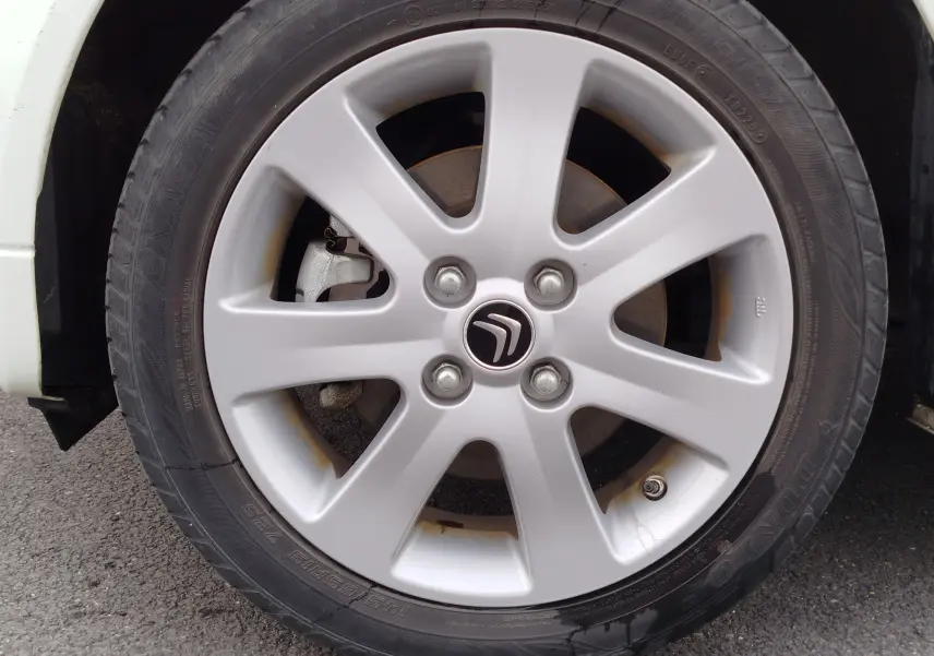 Gros plan sur la jante alliage argentée avec logo Citroën d'une roue avant droite d'une Citroën C-ZERO blanc Antarctique.