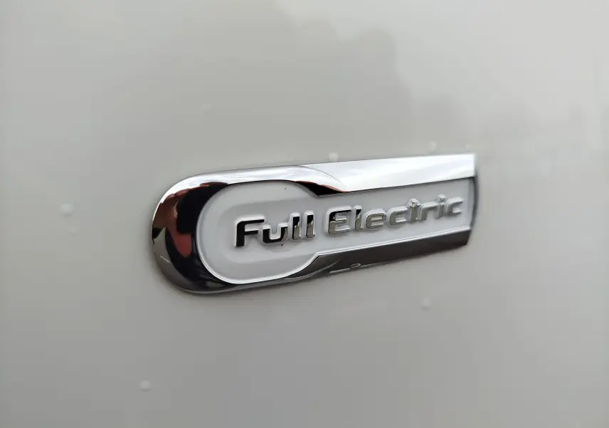 Gros plan sur l’inscription chromée « Full Electric » sur la carrosserie blanche Antarctique d’une Citroën C-ZERO Confort 2020.