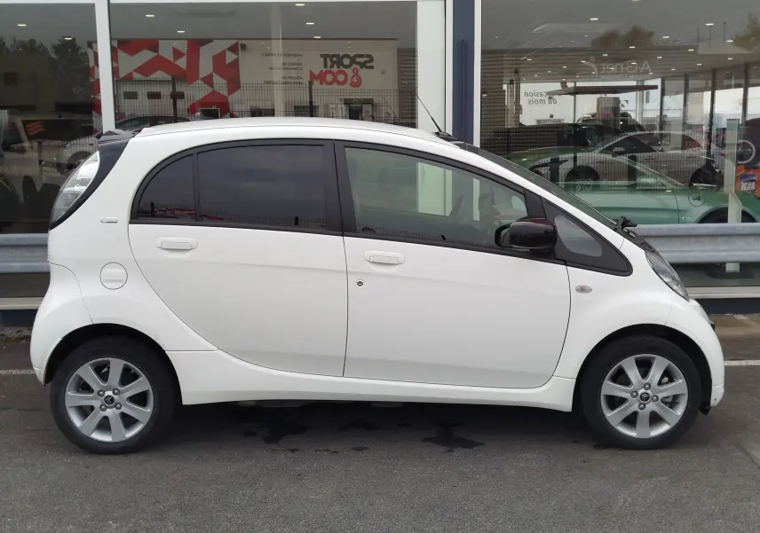 Profil droit d'une Citroën C-ZERO Confort blanche Antarctique, compacte avec vitres teintées et jantes alliage 15 pouces.