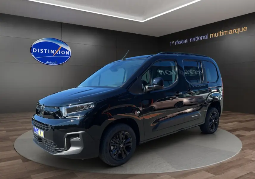 Citroën Berlingo noir en 3/4 avant droit, avec jantes noires et calandre moderne dans un showroom.