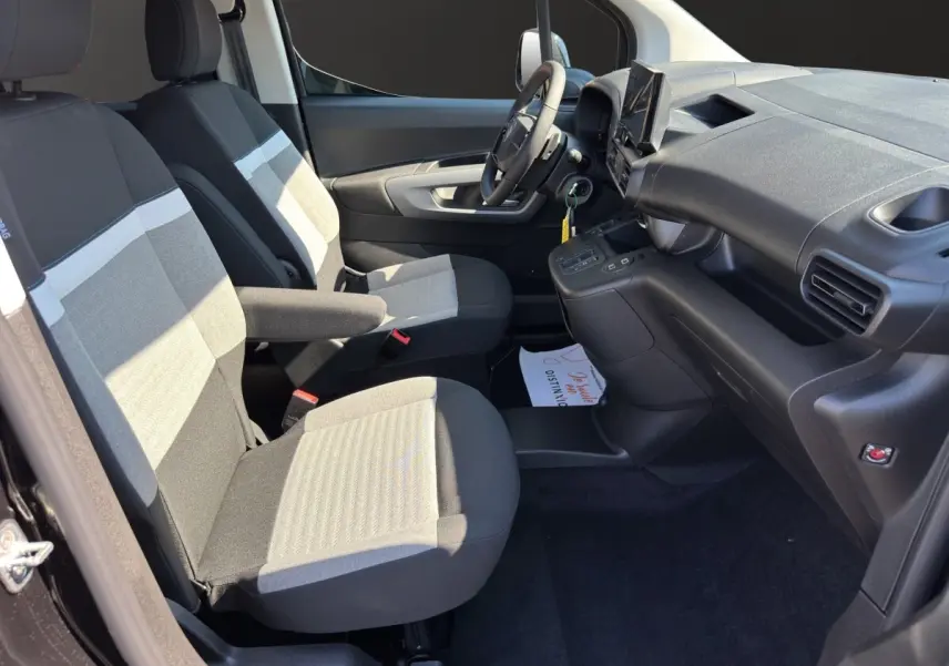 Vue intérieure côté conducteur du Citroën Berlingo noir 2026, montrant sièges tissu bicolore et tableau de bord moderne.