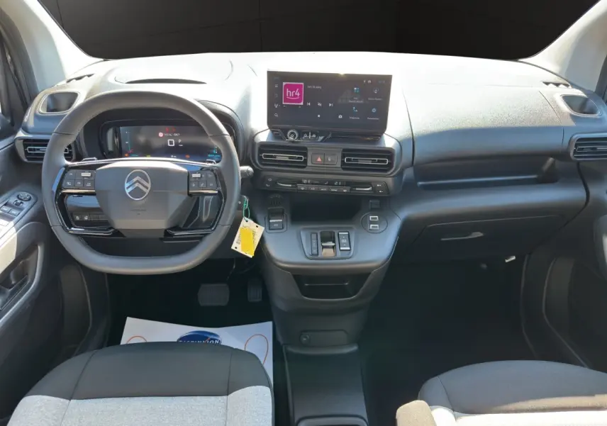 Vue intérieure avant du tableau de bord noir du Citroën Berlingo 2026 avec écran tactile central et volant multifonctions.