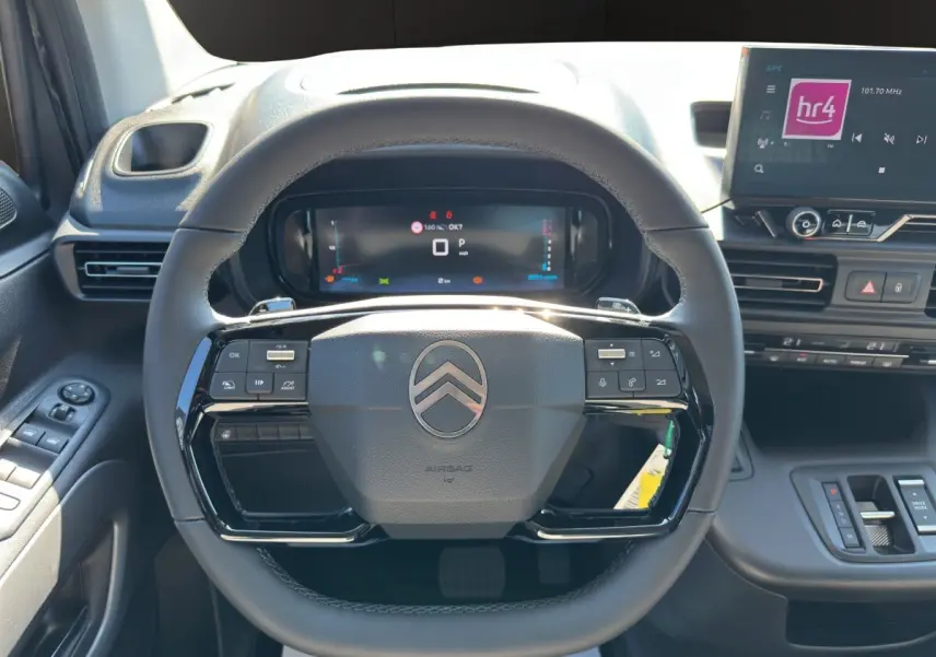 Vue intérieure centrée sur le volant cuir noir multifonctions du Citroën Berlingo 2026 avec tableau de bord digital.