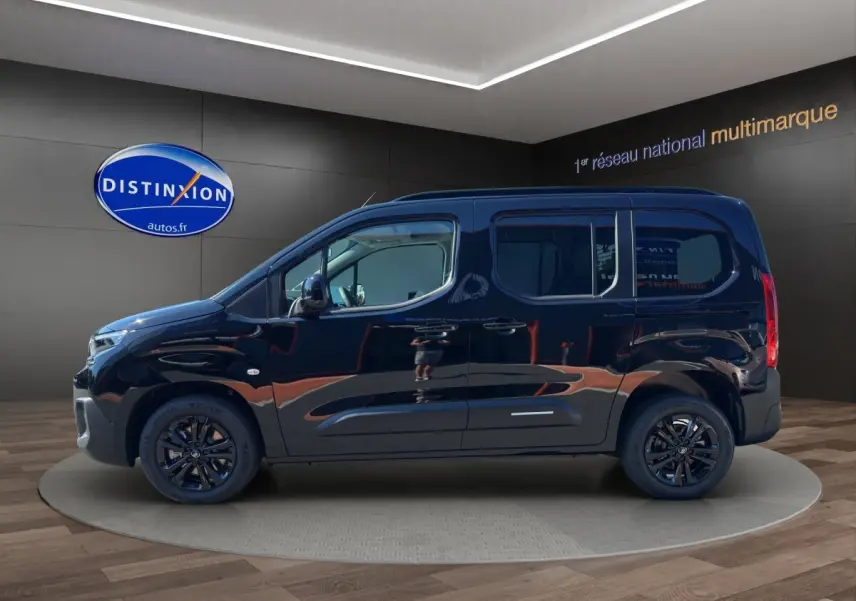 Vue de profil côté gauche d'un Citroën Berlingo noir 2026 avec jantes noires et vitres teintées en showroom.