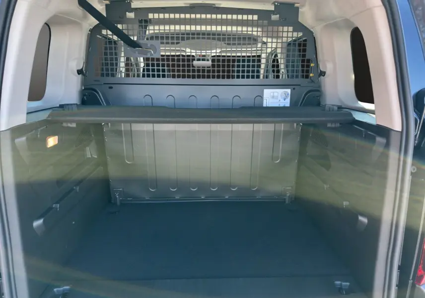 Vue arrière du coffre noir du Citroën Berlingo N1 2026 avec séparation métallique et tablette de rangement.