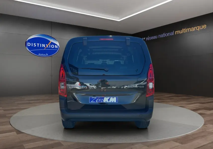 Vue arrière du Citroën Berlingo noir 2026 avec logo et plaque Zero KM dans un showroom intérieur.
