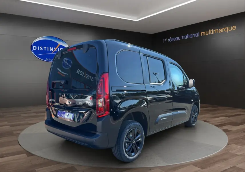 Vue 3/4 arrière droite du Citroën Berlingo noir 2026 avec vitres teintées et jantes noires en showroom.