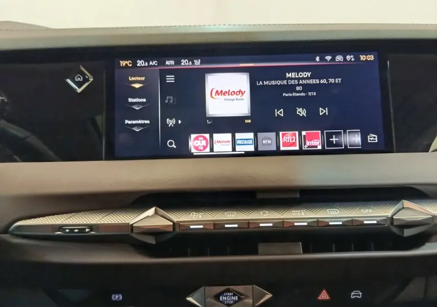 Vue rapprochée de l’écran tactile et des commandes de climatisation du tableau de bord de la DS4 E-TENSE 225 gris clair.
