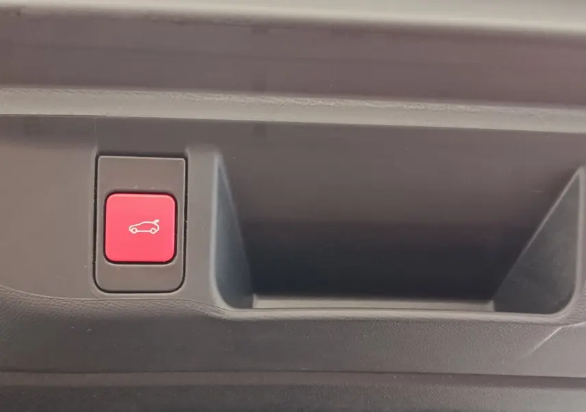 Bouton rouge d'ouverture électrique du coffre sur panneau intérieur d'une DS4 E-TENSE gris clair de 2021.
