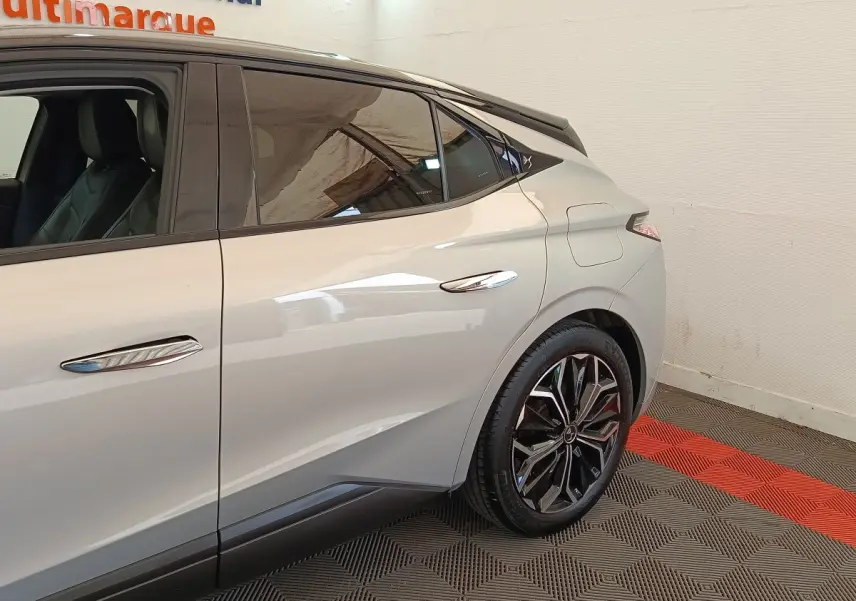 Vue côté droit arrière d'une DS4 E-TENSE 225 gris clair avec jantes noires et toit noir contrasté.